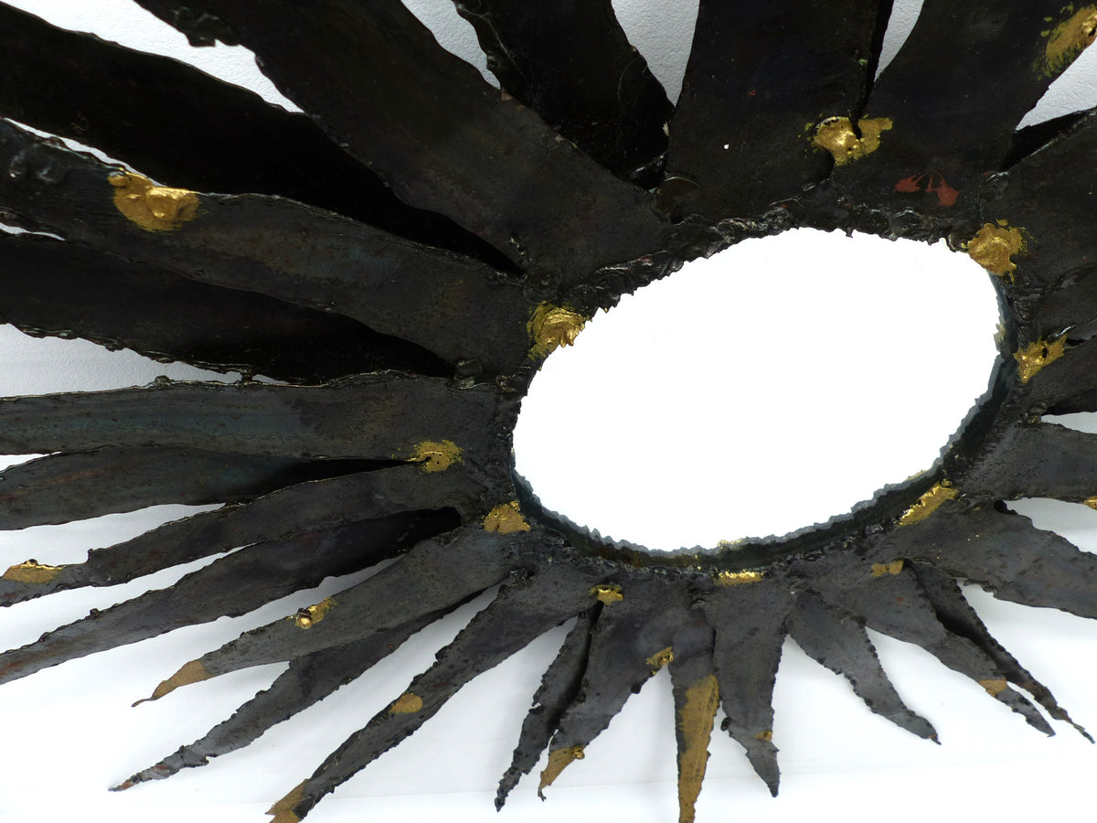 Large brutalist sunburst mirror in patinated metal with gold-toned accents – europe, circa 1970