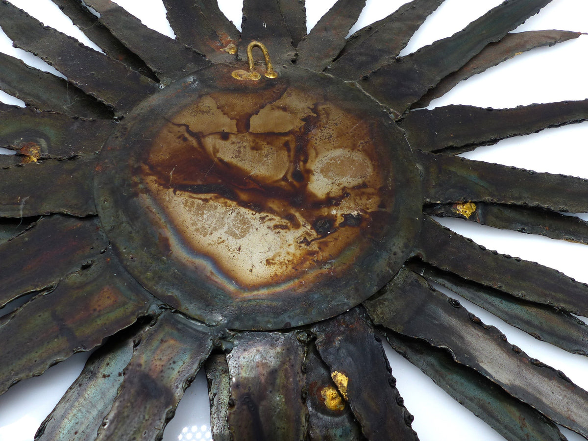 Large brutalist sunburst mirror in patinated metal with gold-toned accents – europe, circa 1970