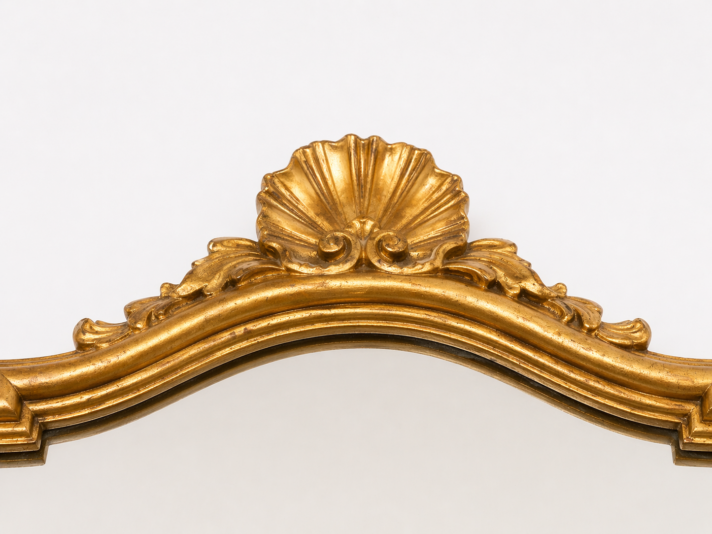 Miroir mural en bois doré style Louis XV, décor rocaille à coquille, circa 1960