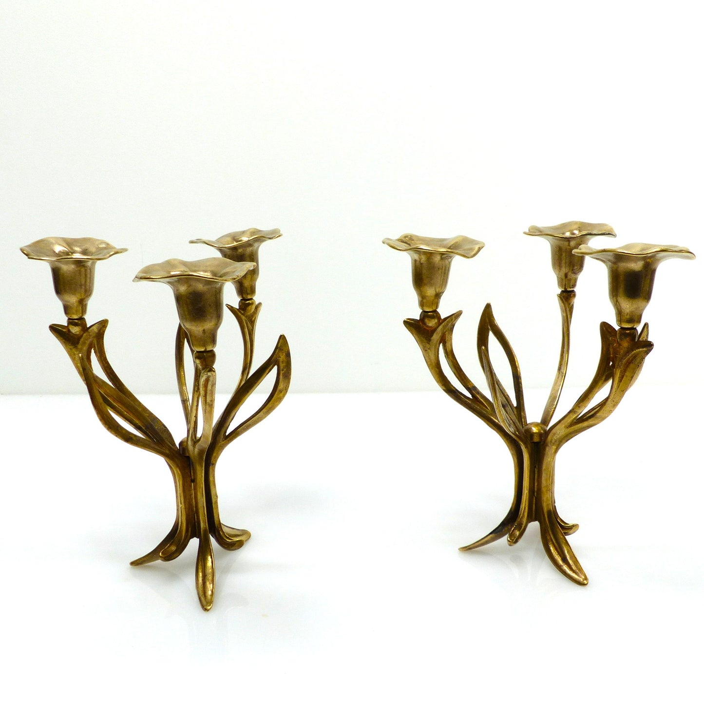 Paire de chandeliers tripodes à trois feux en laiton, décor floral organique, circa 1960–1970