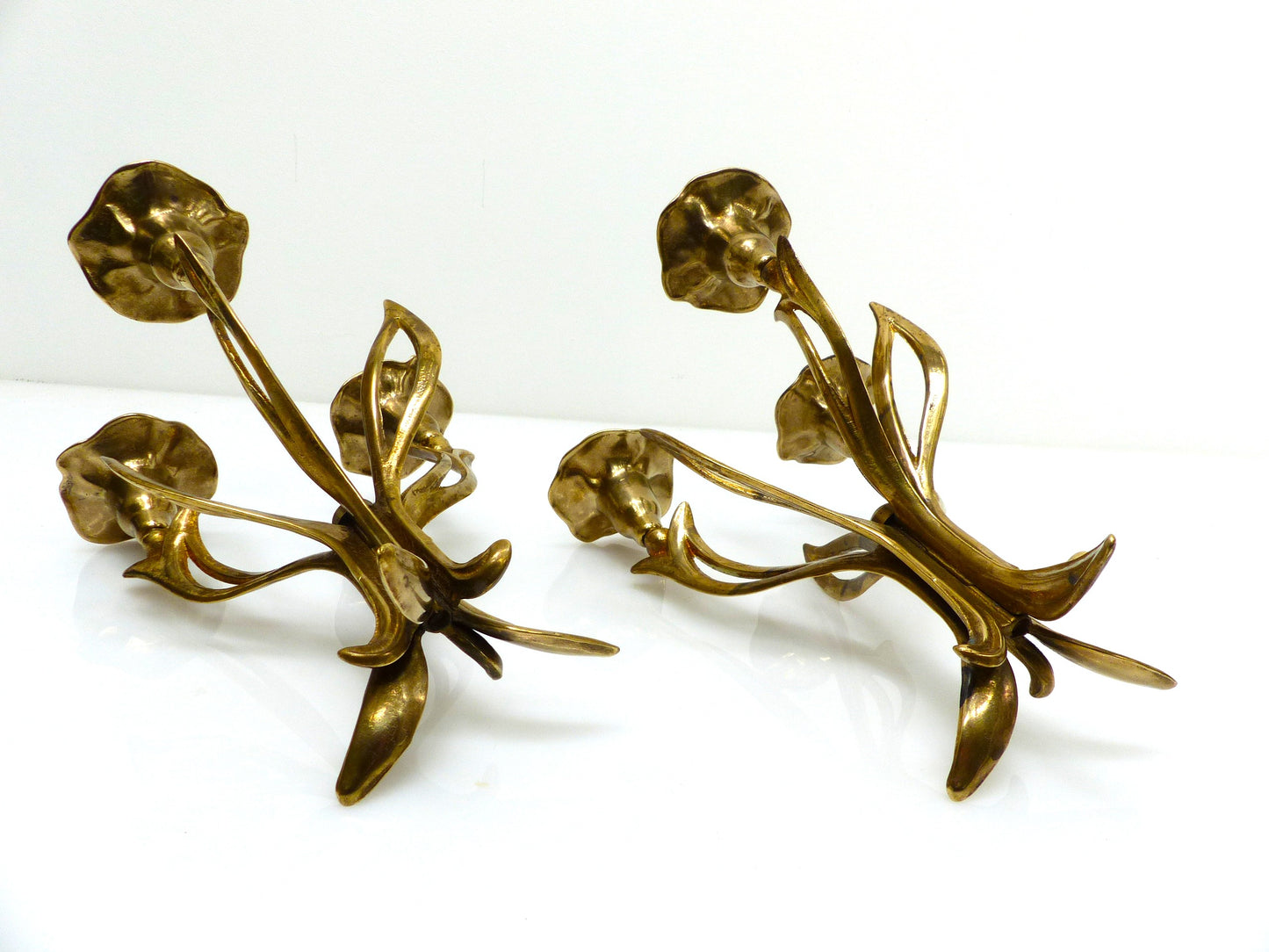 Paire de chandeliers tripodes à trois feux en laiton, décor floral organique, circa 1960–1970